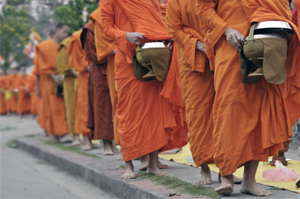 Monks walking in line receiving alms in the morning of Luang Prabang